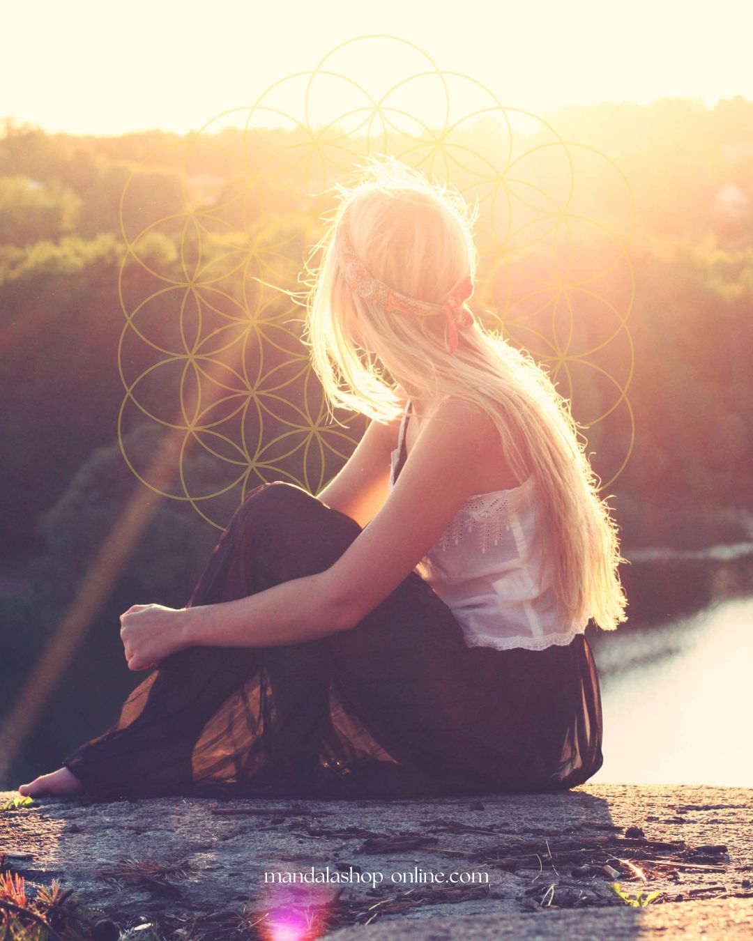 Mujer en meditación con un mandala Flor de la Vida al atardecer