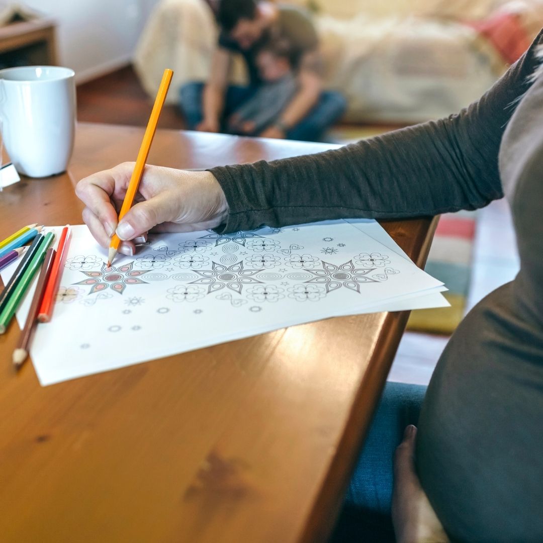 Donna che colora i mandala, usando la creatività per promuovere il rilassamento, ridurre lo stress e promuovere il benessere