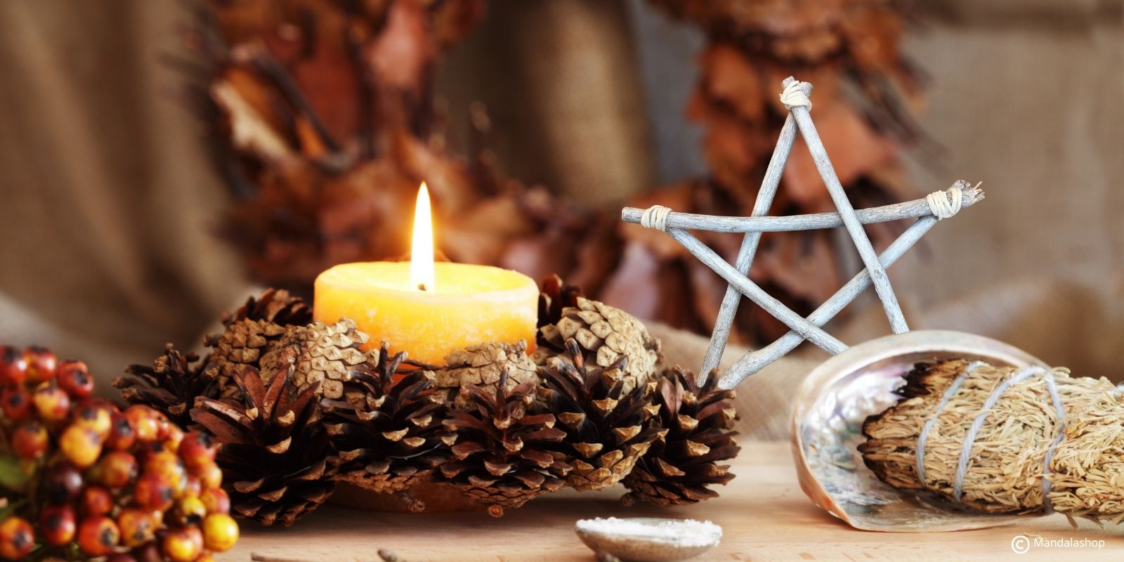 Bougie allumée, pentagramme et plantes d’automne illustrant les symboles et la signification de Samhain